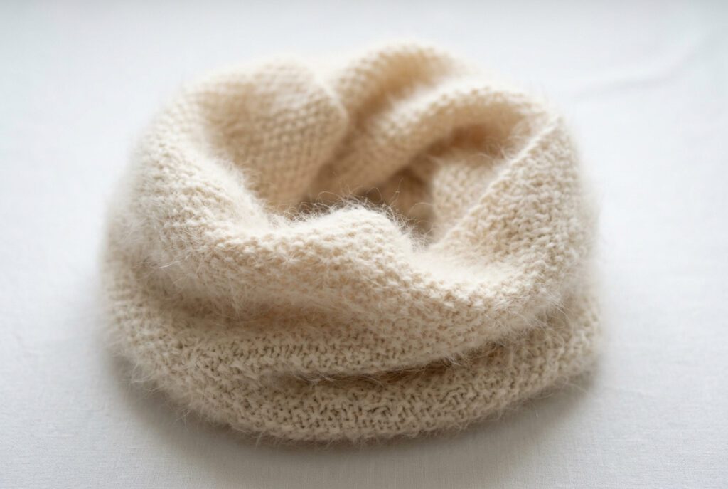 Finished knitted Angora rabbit yarn cowl showing the characteristic halo effect in a completed garment illustrating the visual difference Angora brings to knitted fabric
